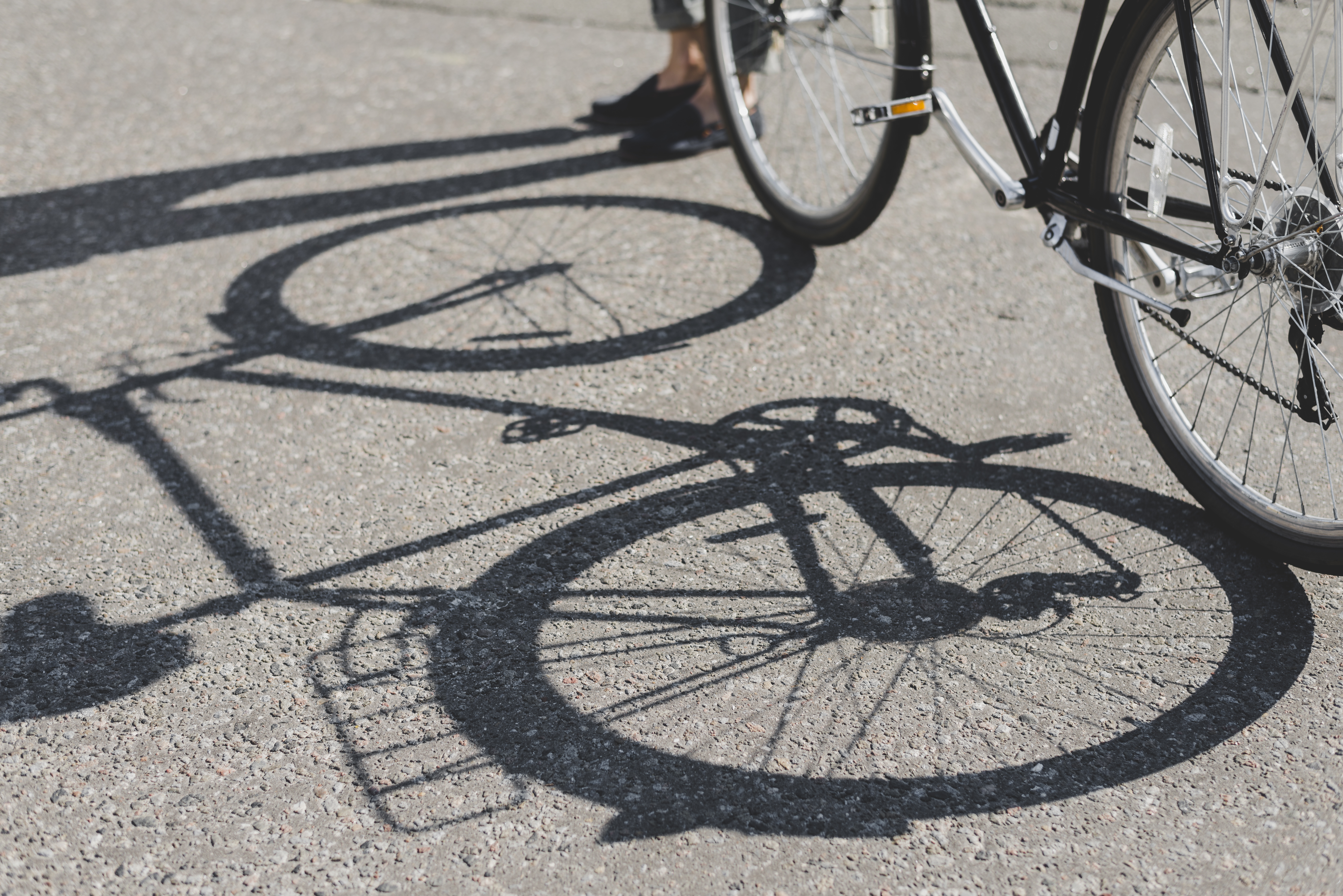 Skyggen af en cykel i asfalt